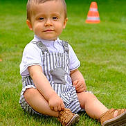Wyatt a rejoint le concours — aidez-le/la à gagner de superbes lots ! toddler, child, grass, outdoor, overalls, white_shirt, sandals, traffic_cone, greenery, summer, cute, portrait, sitting, baby, casual, playful, daylight, nature, smile, young_child