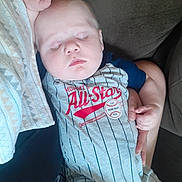 Kenneth joined the competition — help win amazing prizes! baby, sleeping, child, onesie, clothing, person, hand, blanket, arm, couch, comfort, rest, indoor, peaceful, cute, infant, closeup, portrait, soft_lighting, casual