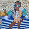 child, beach, sand, swimsuit, floaties, goggles, peace_sign, striped_towel, sunny, outdoor, summer, vacation, playful, confident, person, holiday, fun, water_safety, hair_beads, fashion