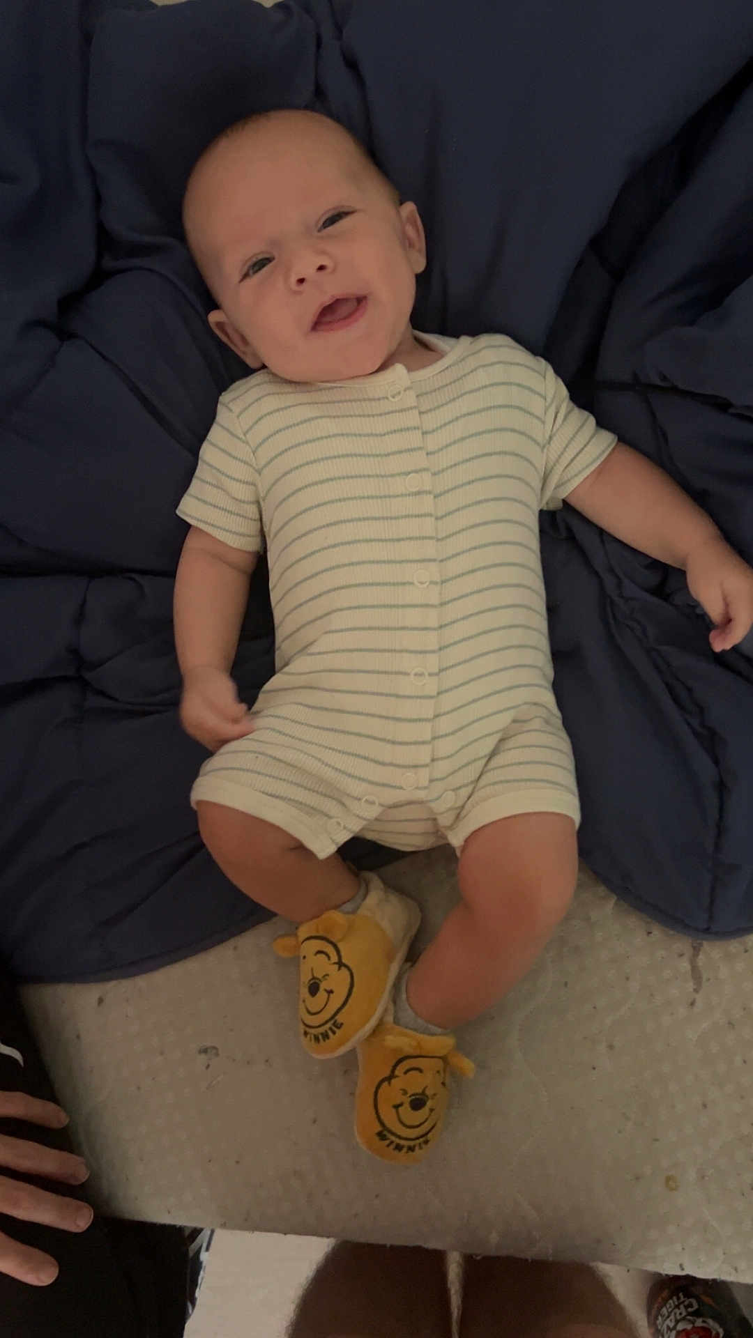 Sidjil a rejoint le concours — aidez-le/la à gagner de superbes lots ! baby, infant, smiling, striped_onesie, blanket, navy_blue, winnie_the_pooh, slippers, footwear, happy, lying_down, candid, hand, legs, cozy, indoor, cute, person, child, sleepwear