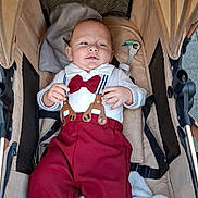 Sidjil participe au concours pour gagner de l'argent avec cette photo : baby, baby_accessories, baby_bed, baby_clothes, baby_face, blanket, child, clothing, comfort, cute, fabric, indoor, infant, person, portrait, red_bow_tie, resting, soft_texture, stroller, suspenders