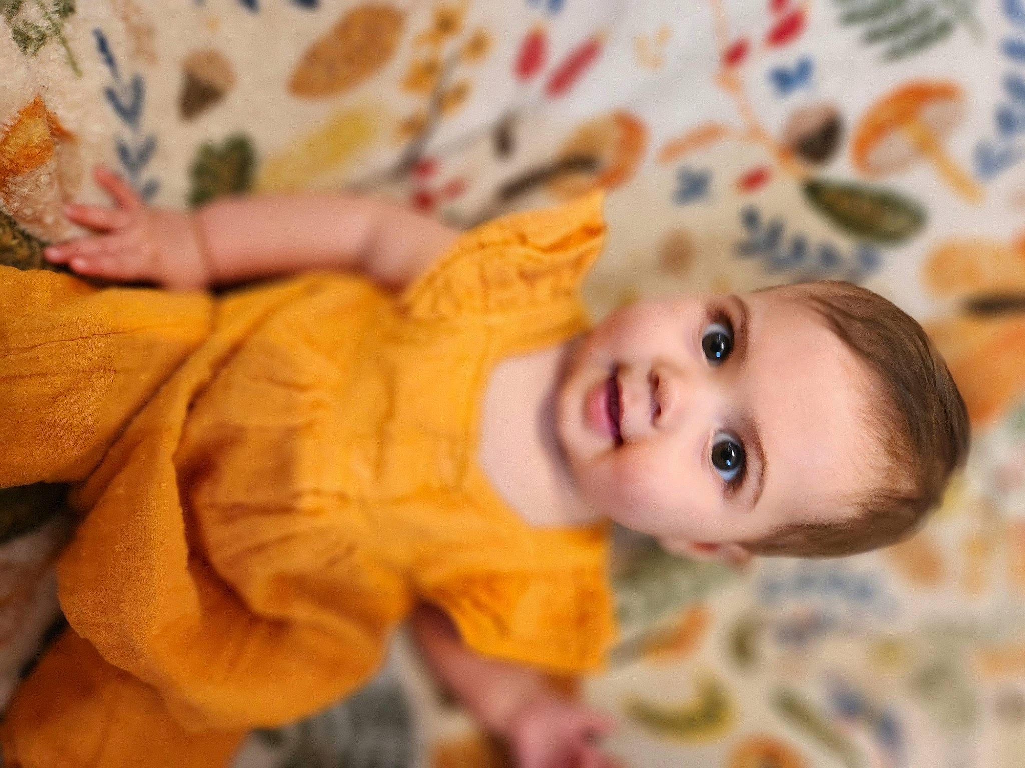 Sage is registered to the contest to win money with this photo: baby, baby_toddler_clothing, cheek, child, doll, eye, eyelash, flooring, happy, human_body, iris, linens, nose, person, room, sitting, skin, toddler, toy, tree