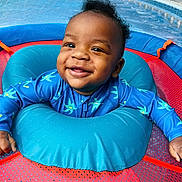 Nhyree is registered to the contest to win money with this photo: baby, smiling, blue_clothing, inflatable_ring, playtime, child, happy, face, mesh_background, starfish_pattern, infant, cute, outdoor, toddler, water_toy, joyful, bright_colors, young_child, fun, portrait