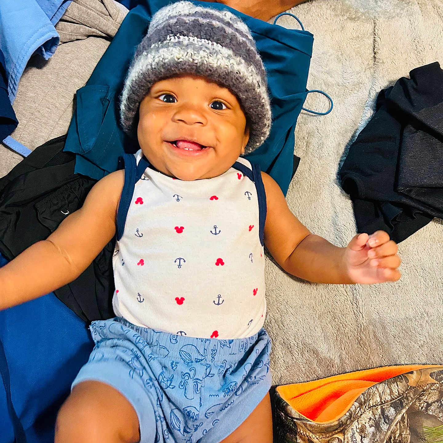 Nhyree joined the competition — help win amazing prizes! baby, cheerful, child, clothing, cute, fabric, face, hand, happy, hat, indoors, infant, knitted_hat, lying_down, patterned, person, shorts, smiling, soft_surface, textile