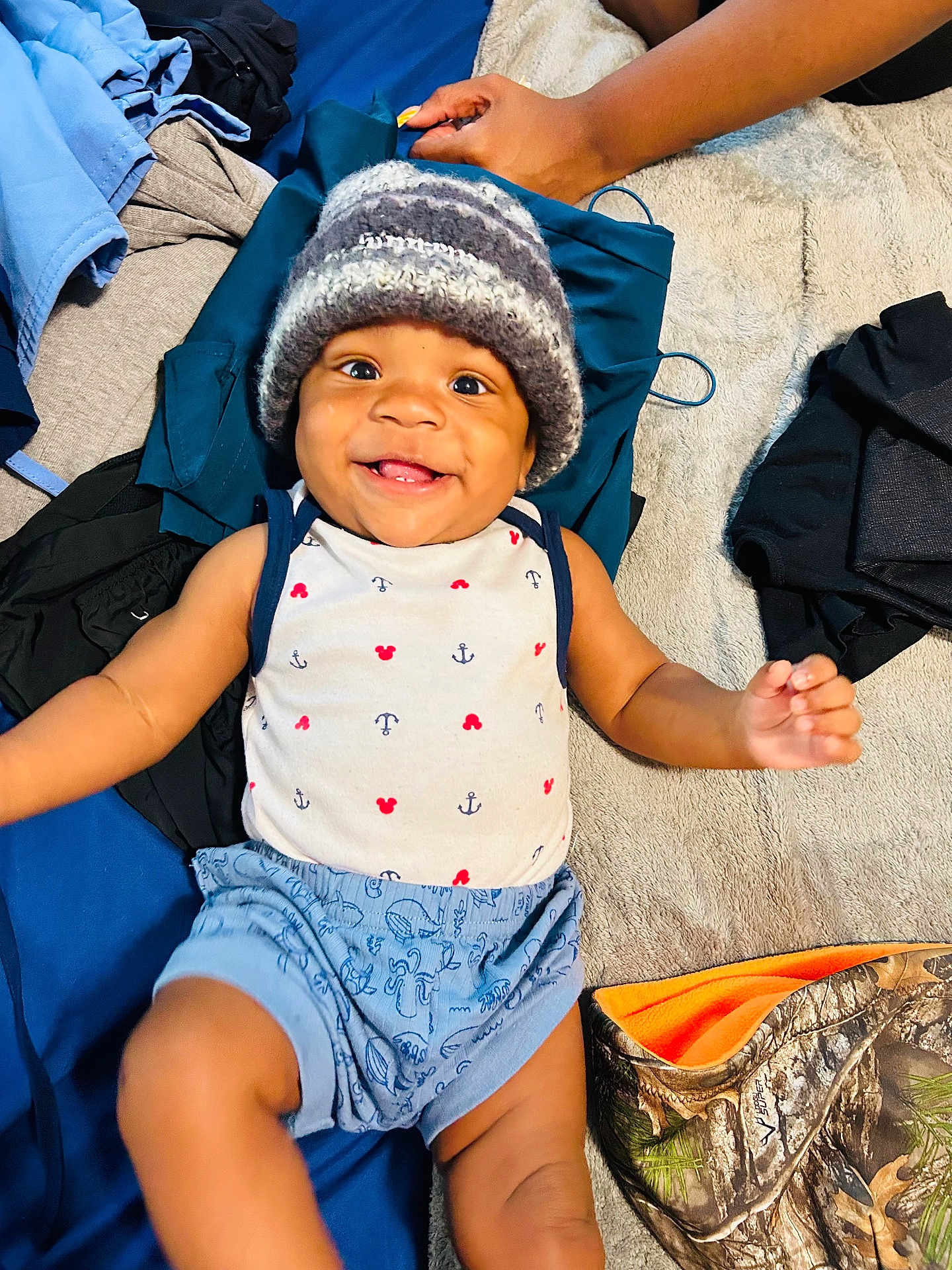 Nhyree joined the competition — help win amazing prizes! baby, child, smiling, hat, knitted_hat, clothing, shorts, patterned, happy, lying_down, infant, cute, person, face, cheerful, indoors, fabric, textile, soft_surface, hand