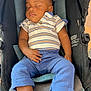 baby, blue_pants, child, clothing, comfortable, cute, footwear, indoors, infant, peaceful, person, portrait, relaxed, resting, seated, shoes, sleeping, striped_shirt, stroller, young_child