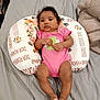Dior joined the competition — help win amazing prizes! baby, infant, pink_onesie, pillow, floral_pattern, bed, gray_sheet, blanket, person, child, cute, relaxed, indoors, lying_down, skin, feet, hands, curly_hair, expression, soft_fabric