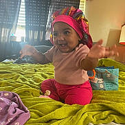 Dior joined the competition — help win amazing prizes! baby, child, pink_clothing, bonnet, bed, blanket, green, toy, pillow, curtains, room, indoor, smiling, happy, reaching, sitting, stuffed_animal, lamp, window, child_indoor