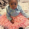 child, toddler, baby, portrait, sitting, bedroom, bed, denim_jacket, pink_dress, tutu, heart_pattern, hair_bow, red_bow, black_shoes, fashion, cute, serious_expression, indoors, bedding, photography
