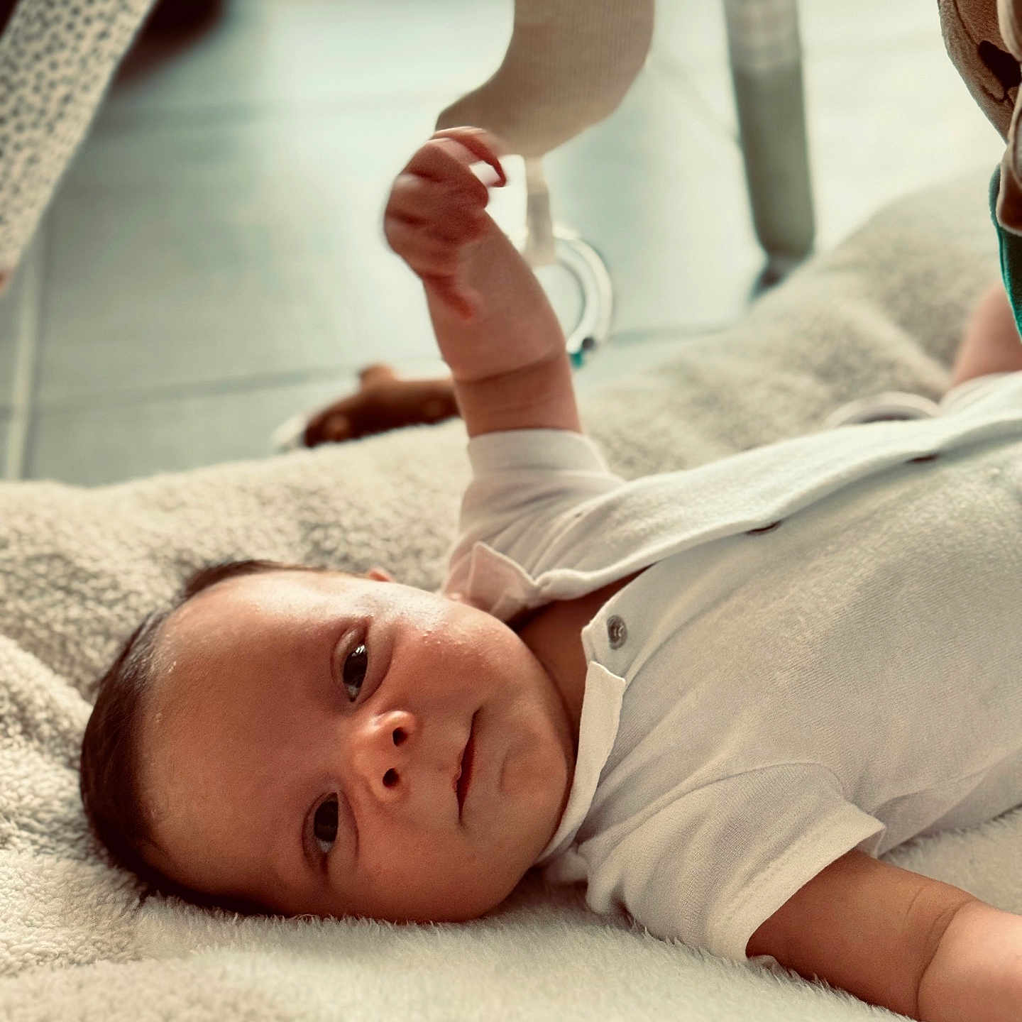 Jules participe au concours pour gagner de l'argent avec cette photo : baby, blanket, child, comfort, crescent_moon, curious, face, floor, hand, head, indoor, infant, lying_down, play, relax, smile, soft, toy, warm_light, white_clothing