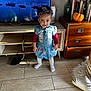 Seta a rejoint le concours — aidez-le/la à gagner de superbes lots ! toddler, child, denim_dress, headband, smiling, indoor, television, wooden_floor, cabinet, pumpkin, books, living_room, cozy, floor_tiles, cute, person, portrait, decor, happy, standing