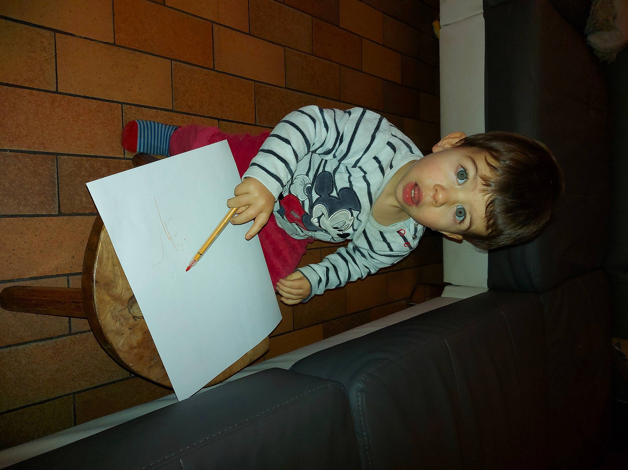 Bjõrn participe au concours pour gagner de l'argent avec cette photo : brick, brickwork, cardboard, child, comfort, couch, flooring, fun, lap, paper, paper_product, person, reading, room, sitting, sofa_bed, surprise, t_shirt, toddler, wood