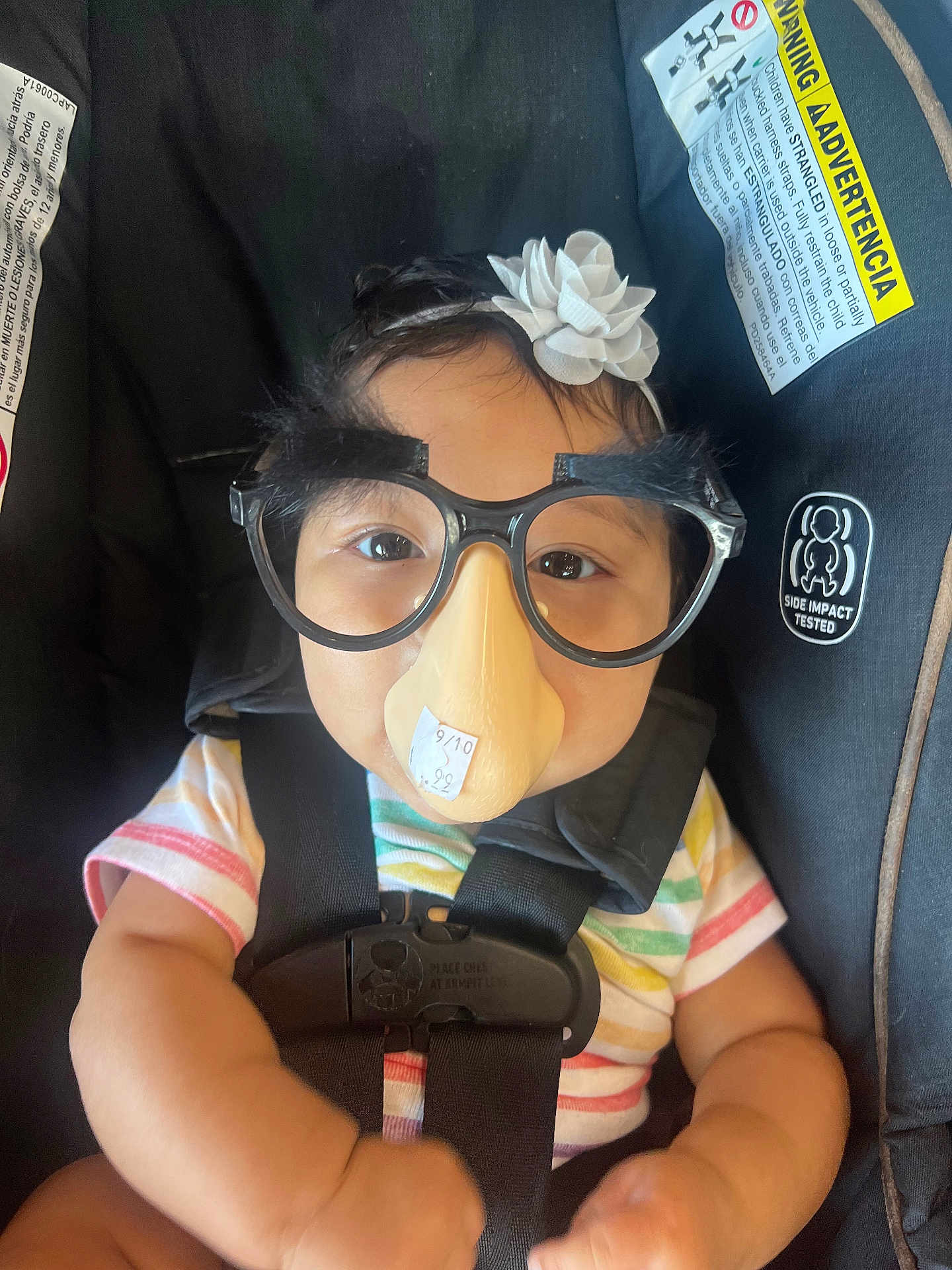 Kendra joined the competition — help win amazing prizes! baby, child, disguise, glasses, fake_nose, headband, car_seat, safety_harness, striped_shirt, smile, face, cute, indoors, funny, portrait, infant, black_straps, warning_label, seat_belt, humor