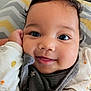 Kendra is registered to the contest to win money with this photo: baby, close_up, smile, face, child, infant, hand, eyes, clothing, cozy, portrait, cute, indoors, soft, expression, cheeks, warm, head, sleeve, fabric