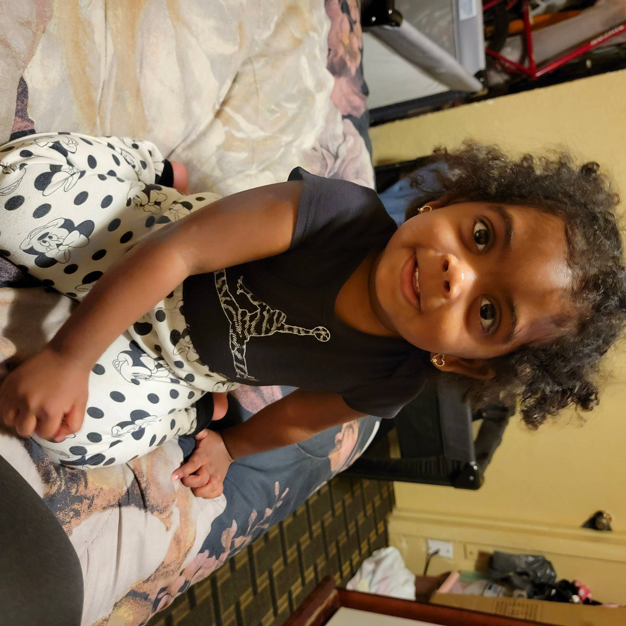 Aavani is registered to the contest to win money with this photo: arm, black_hair, child, comfort, elbow, facial_expression, fashion, fun, hairstyle, happy, human_leg, joy, pattern, people, person, product, room, sitting, smile, t_shirt