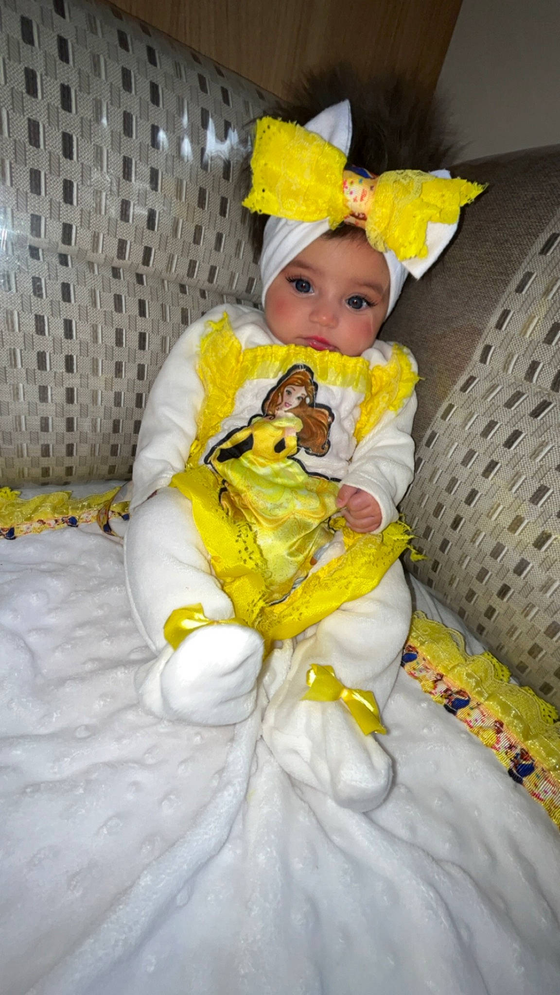 Calyana participe au concours pour gagner de l'argent avec cette photo : baby, baby_products, baby_toddler_clothing, chair, child, comfort, costume, couch, doll, dress, event, face, fashion_design, fun, happy, headwear, linens, person, sitting, textile