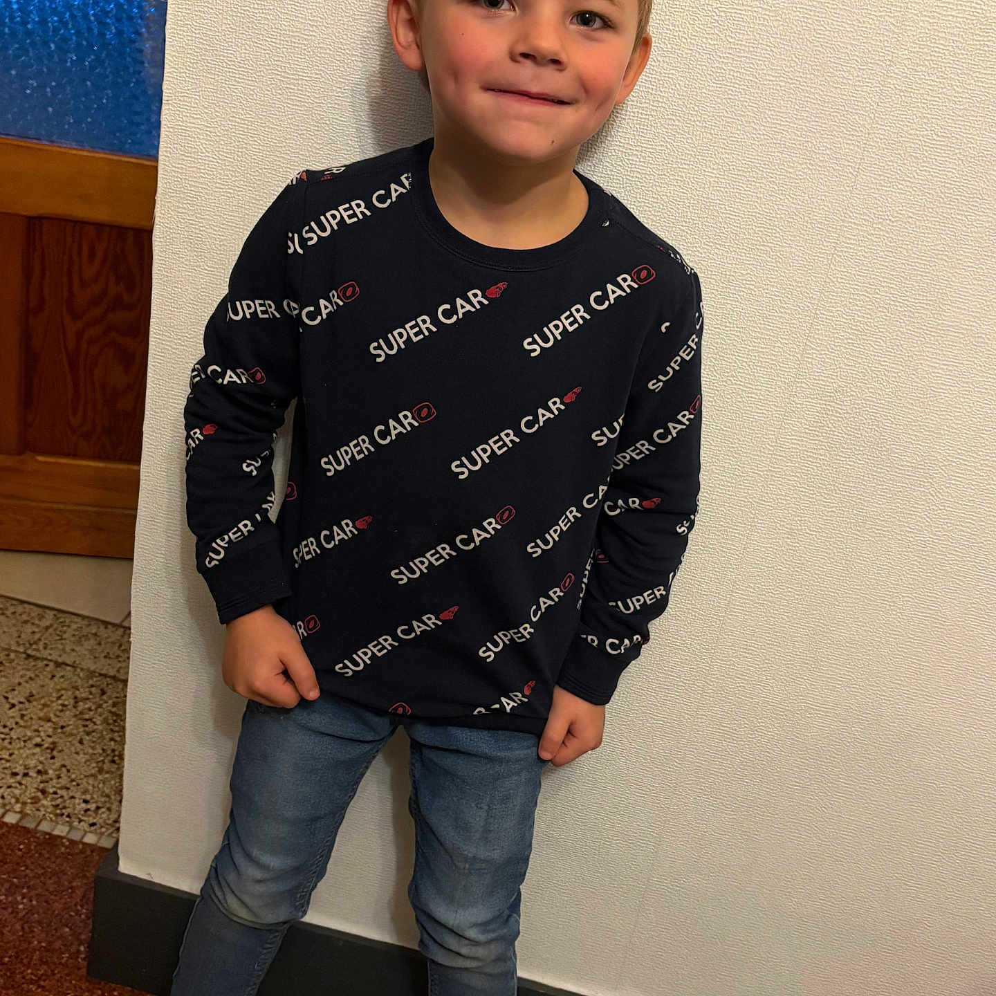 Mallessyo participe au concours pour gagner de l'argent avec cette photo : background, boy, casual, child, clothing, face, floor, footwear, hair, happy, indoor, jeans, light, person, portrait, pose, smiling, standing, sweater, wall
