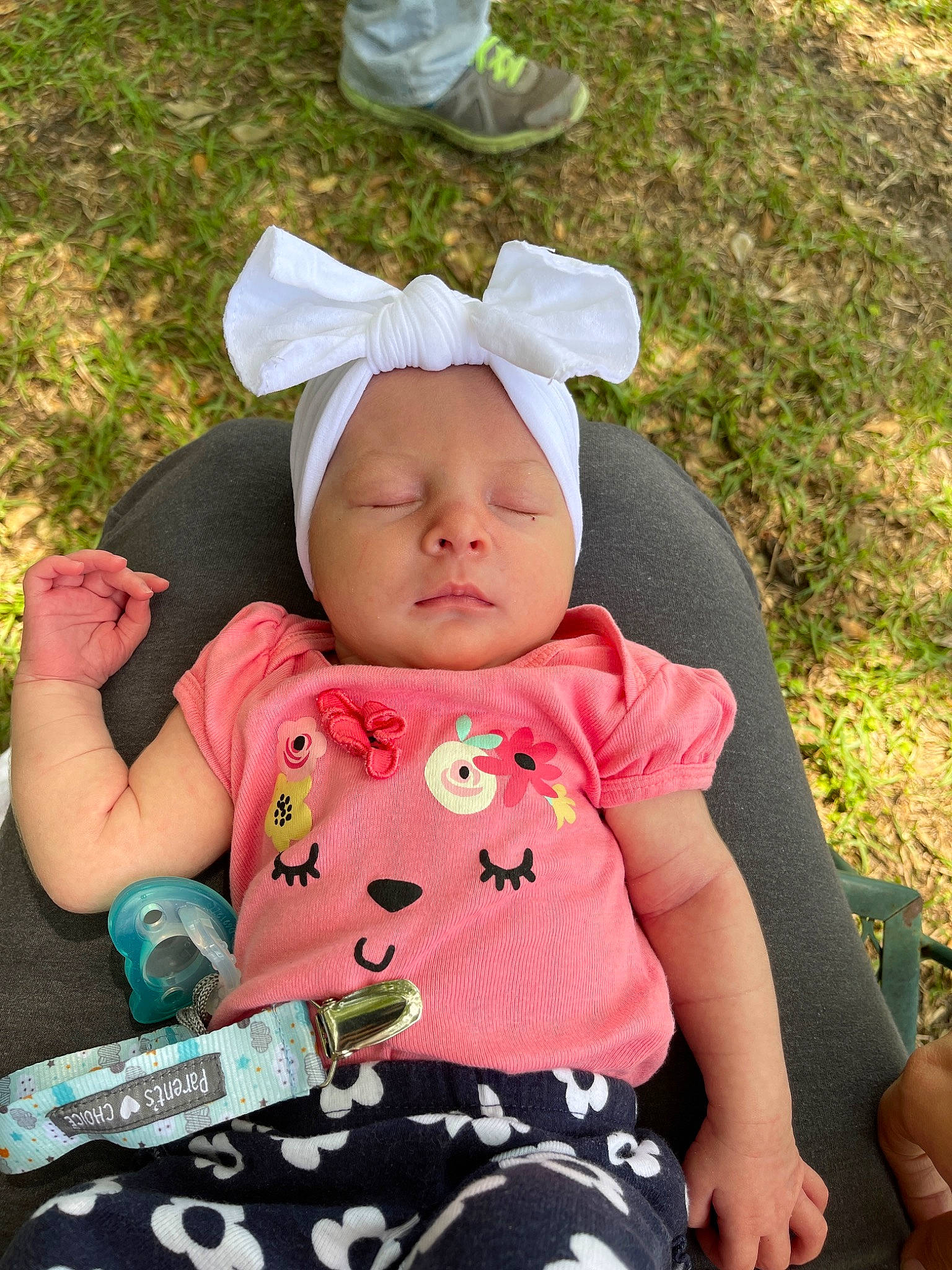 Lakelyn is registered to the contest to win money with this photo: baby, baby_carriage, baby_products, baby_toddler_clothing, cap, cheek, child, comfort, fashion_accessory, grass, green, happy, headwear, leisure, pattern, people_in_nature, person, pink, sitting, sleeve