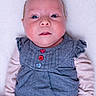 baby, infant, child, portrait, close_up, blue_outfit, denim, buttons, striped_sleeves, soft_surface, white_background, face, eyes, skin, expression, lying_down, clothing, cute, newborn, hands