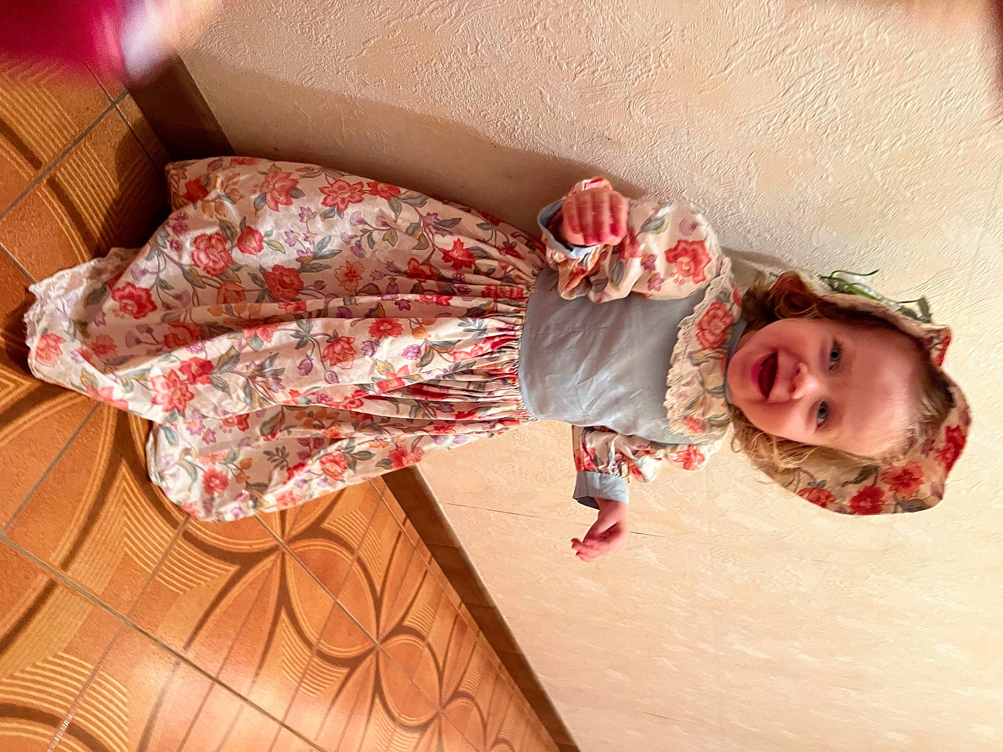 Kaïssy participe au concours pour gagner de l'argent avec cette photo : baby, baby_toddler_clothing, carmine, child, comfort, couch, dress, floor, flooring, foot, happy, hardwood, human_leg, pattern, peach, person, pink, room, toddler, tree