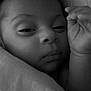 Quentin is registered to the contest to win money with this photo: baby, infant, closeup, black_and_white, blanket, sleepy, hand, face, portrait, newborn, soft, peaceful, cute, wrapped, skin, expression, lying_down, indoors, calm, toddler