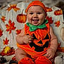 Nylann a rejoint le concours — aidez-le/la à gagner de superbes lots ! autumn, baby, blanket, child, costume, cute, decor, fall_leaves, festive, green_collar, happy, holiday, indoors, orange, pinecones, pumpkin, pumpkin_costume, seasonal, sitting, smiling
