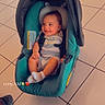 baby, child, infant, smiling, happy, car_seat, stroller, seated, indoors, tiled_floor, portrait, casual, clothing, striped_outfit, socks, safety_harness, teal, backrest, timestamp, heart_emoji