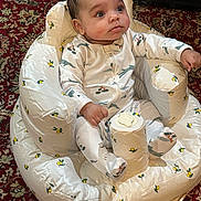 Jakaiven is registered to the contest to win money with this photo: baby, infant, child, portrait, sitting, cushion, baby_seat, onesie, clothing, face, eyes, hair, indoor, carpet, patterned, furniture, relaxed, awake, cute, photography