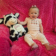Anna joined the competition — help win amazing prizes! baby, child, smiling, stuffed_animal, cow_plush, pink_blanket, clothing, sitting, happy, infant, face, foot, hand, toy, indoor, cute, portrait, person, bow, texture