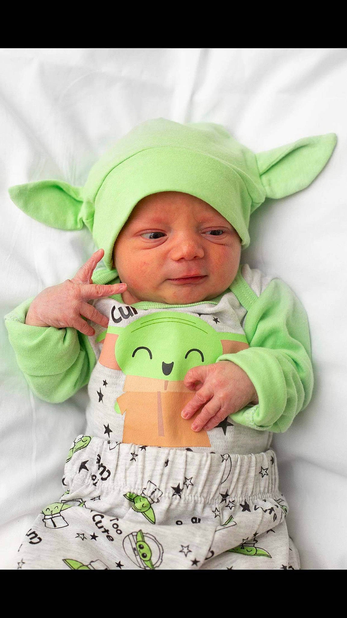 Kian is registered to the contest to win money with this photo: baby, baby_products, baby_toddler_clothing, cap, child, eye, face, happy, head, headwear, hood, jacket, linens, outerwear, pattern, person, personal_protective_equipment, sleeve, t_shirt, textile