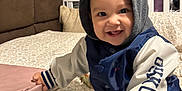 Haruto joined the competition — help win amazing prizes! toddler, child, smiling, hoodie, jacket, bed, blanket, sippy_cup, pink_case, indoor, cozy, happy, person, clothing, furniture, playful, baby, cute, portrait, home
