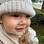 child, toddler, smile, hat, knit_hat, jacket, button, face, outdoor, greenery, trees, house, street, closeup, warm_clothing, cute, baby, portrait, happy, person