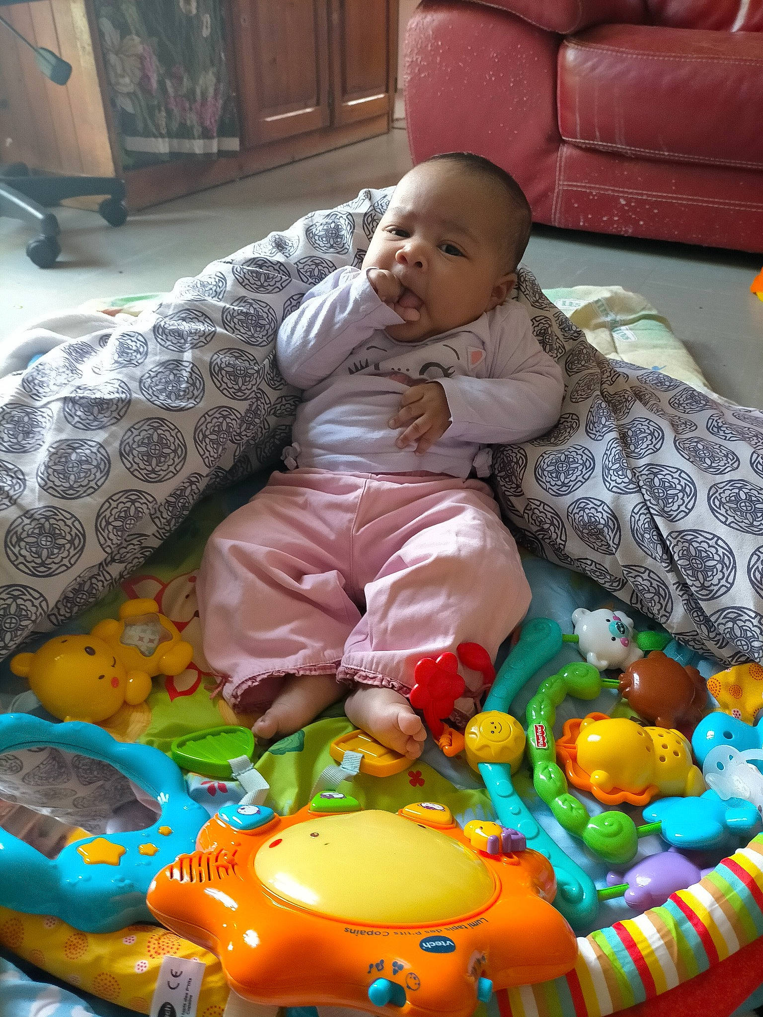 Ayomidé a rejoint le concours — aidez-le/la à gagner de superbes lots ! baby, baby_products, baby_toddler_clothing, baby_toys, ball, child, comfort, couch, event, flooring, fun, person, plastic, play, product, room, sitting, smile, textile, toddler