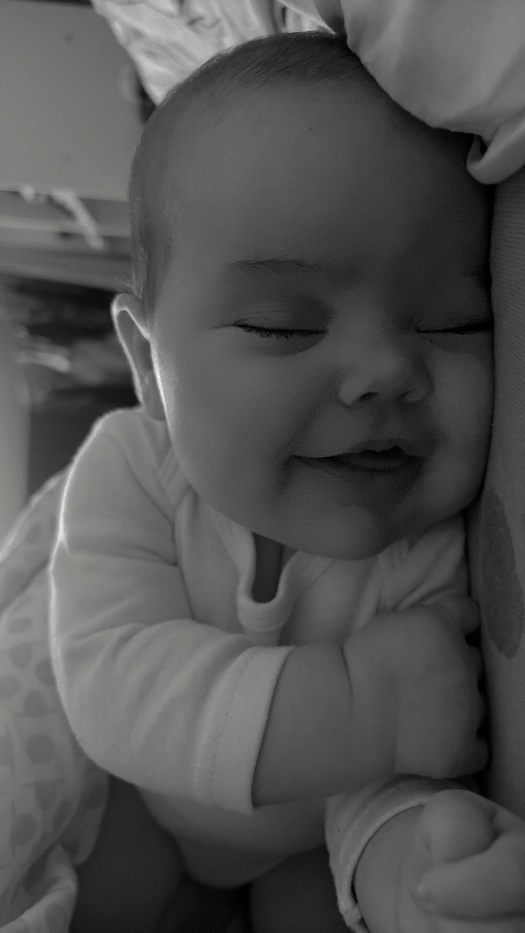 baby, black_and_white, cheeks, child, closeup, cozy, cute, face, hand, happy, indoors, infant, napping, onesie, peaceful, portrait, resting, sleeping, smiling, soft