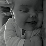 Joyce a rejoint le concours — aidez-le/la à gagner de superbes lots ! baby, sleeping, smiling, black_and_white, closeup, face, infant, cozy, onesie, hand, cheeks, peaceful, cute, portrait, child, soft, napping, indoors, happy, resting