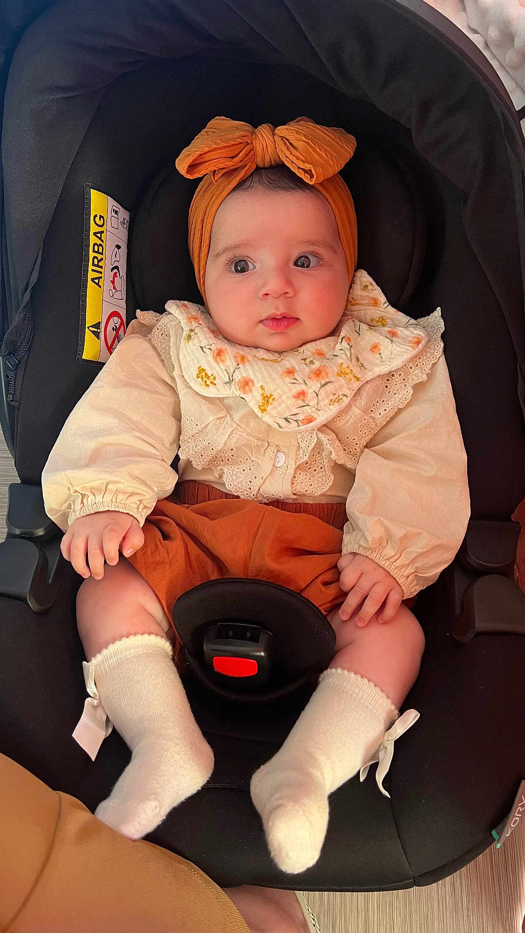 Léa participe au concours pour gagner de l'argent avec cette photo : baby, child, infant, car_seat, headband, bow, socks, clothing, cute, portrait, person, sitting, indoors, face, expression, hands, feet, fabric, seatbelt, footwear