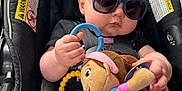 Alena is registered to the contest to win money with this photo: accessory, baby, car_seat, child, clothing, comfort, cute, headwear, indoor, infant, person, playtime, plush_toy, relaxed, seatbelt, security, small_person, soft_toy, sunglasses, toy