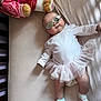 baby, tutu, sunglasses, plush_toy, bed, crib, socks, infant, clothing, cute, soft, sleepwear, toy, pink, white, child, person, relaxing, laying, fashion