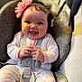 Ember is registered to the contest to win money with this photo: baby, infant, smiling, pink_headband, flower_headband, car_seat, harness, onesie, chubby_cheeks, laughing, hands, portrait, closeup, seat_cushion, fabric, buckle, indoors, cute, hair, happy
