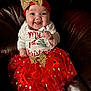 Ember joined the competition — help win amazing prizes! baby, child, smiling, red_skirt, gold_bow, headband, christmas_outfit, holiday, celebration, festive, cute, sitting, leather_chair, happy, portrait, indoors, clothing, toddler, face, person
