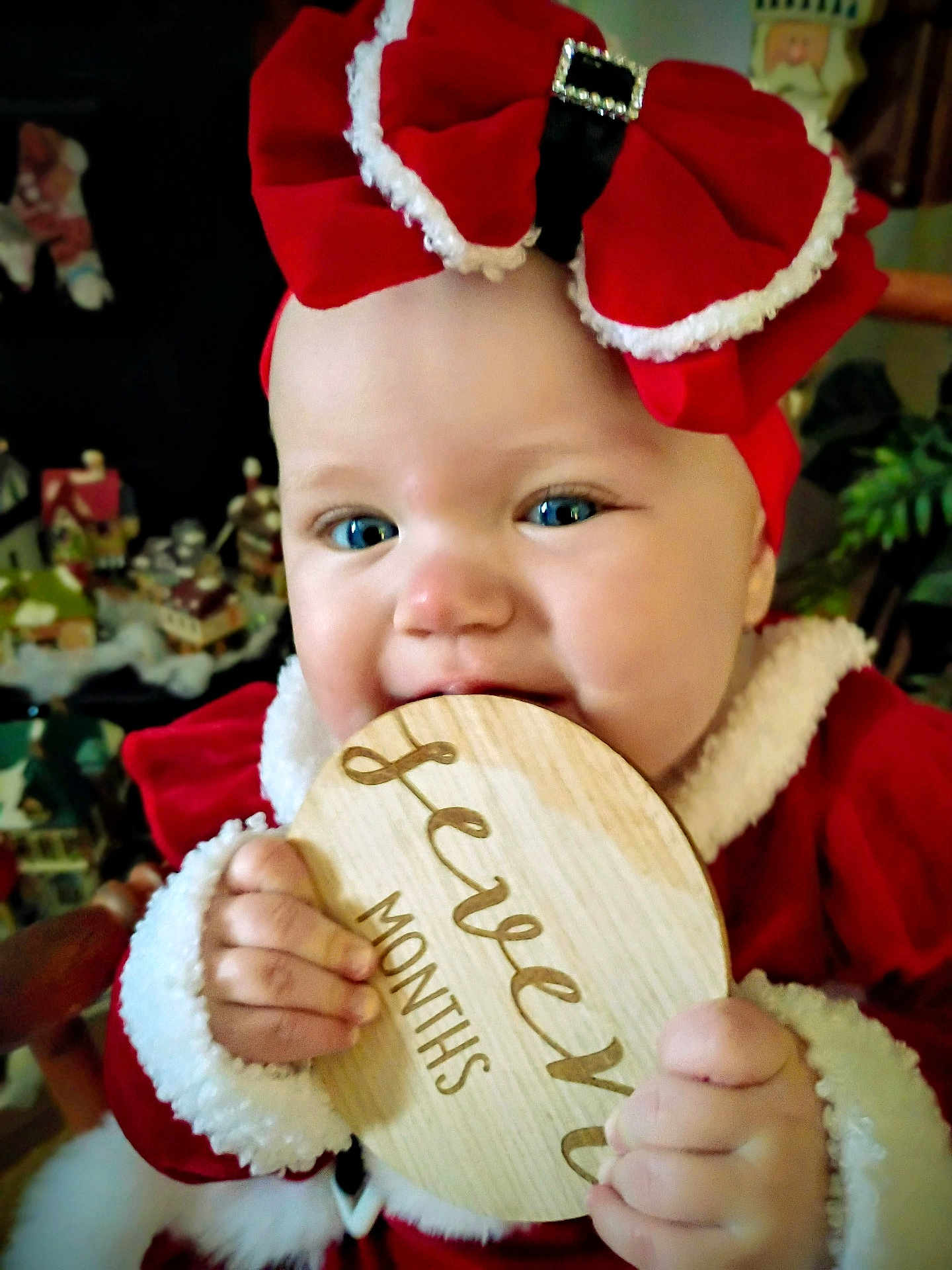 Covelea joined the competition — help win amazing prizes! baby, child, infant, red_bow, red_clothing, festive, holiday, wooden_plaque, twelve_months, smiling, face, hand, blue_eyes, cheeks, indoors, decorations, toy, candid, portrait, cute