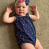 baby, child, infant, carpet, blue_outfit, stars, headband, bow, red, white, blue, arms, legs, skin, face, expression, indoor, floor, person, cute