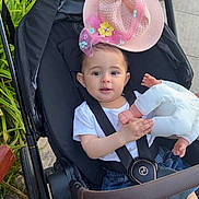 Julia a rejoint le concours — aidez-le/la à gagner de superbes lots ! baby, stroller, hat, doll, child, outdoor, greenery, cute, infant, pink, flowers, toy, seatbelt, happy, casual_clothing, jeans, face, person, summer, playful