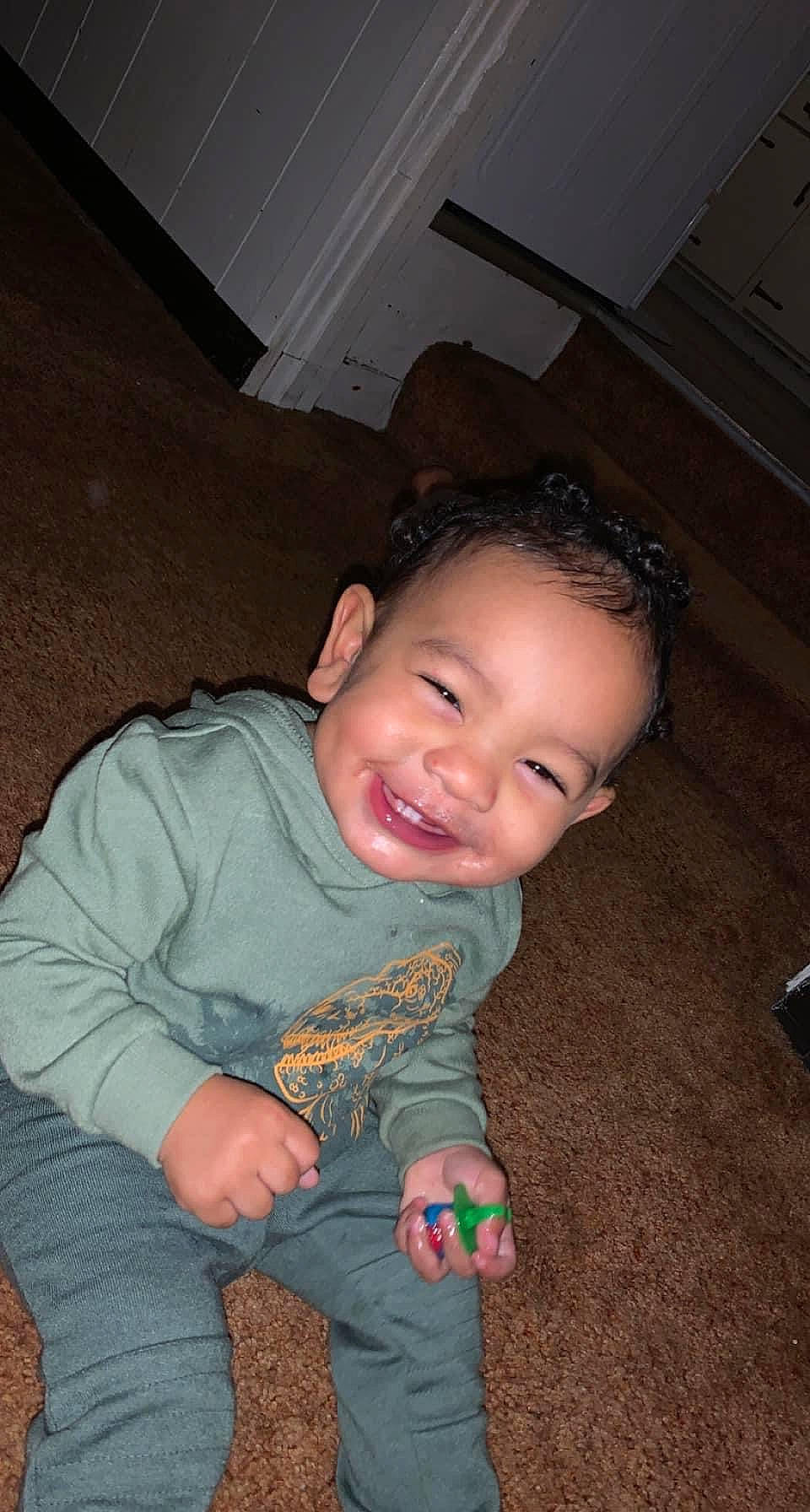 Makai is registered to the contest to win money with this photo: arm, baby_toddler_clothing, brown, cheek, chin, eye, facial_expression, finger, flash_photography, hair, happy, head, iris, joy, mouth, nose, organ, person, skin, sleeve