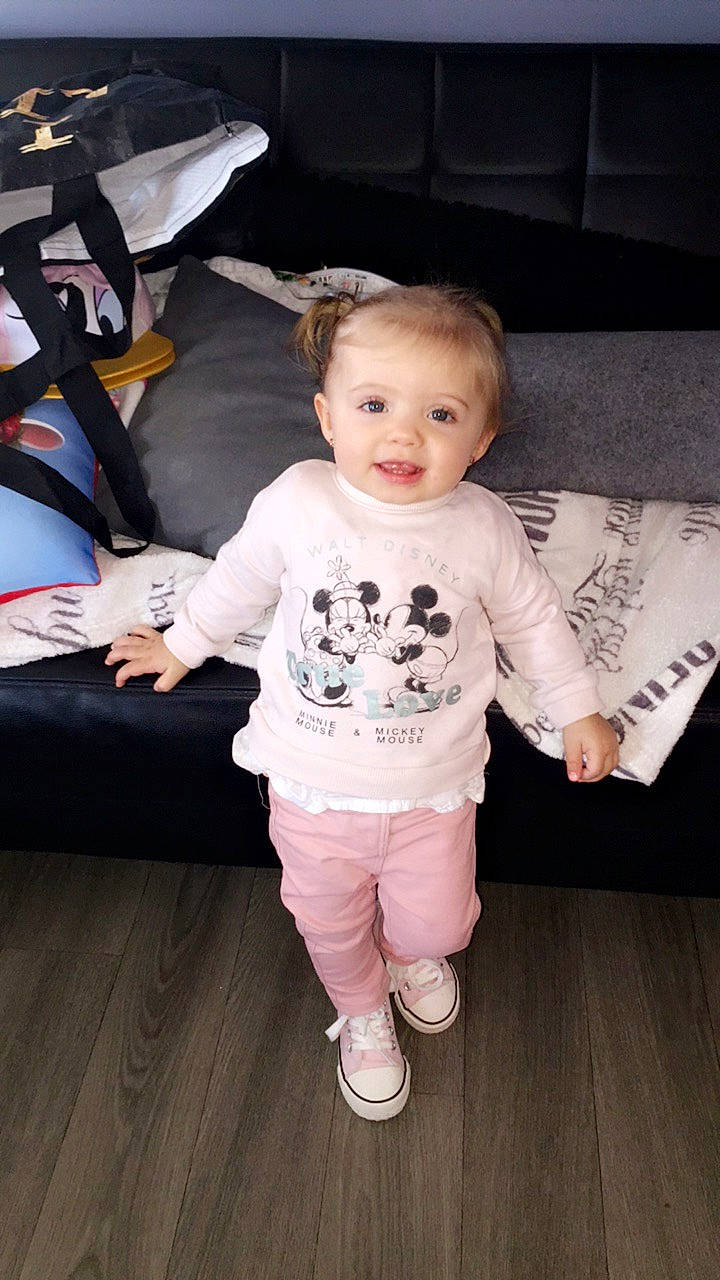 Leena participe au concours pour gagner de l'argent avec cette photo : arm, baby, baby_toddler_clothing, cheek, child, footwear, outerwear, person, shoe, skin, sleeve, smile, standing, t_shirt, toddler