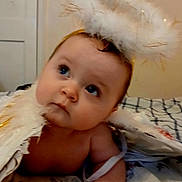 Leah is registered to the contest to win money with this photo: angel_costume, baby, bed, blanket, child, costume, curious, cute, eyes, fairy_lights, fluffy, halo, hand, headband, indoor, infant, portrait, skin, sleepwear, soft_lighting