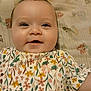 Leah is registered to the contest to win money with this photo: baby, child, smiling, face, portrait, infant, cute, floral_dress, patterned_clothing, lying_down, blanket, happy, young_child, indoors, skin, head, eyes, small_hair_tuft, cheeks, person