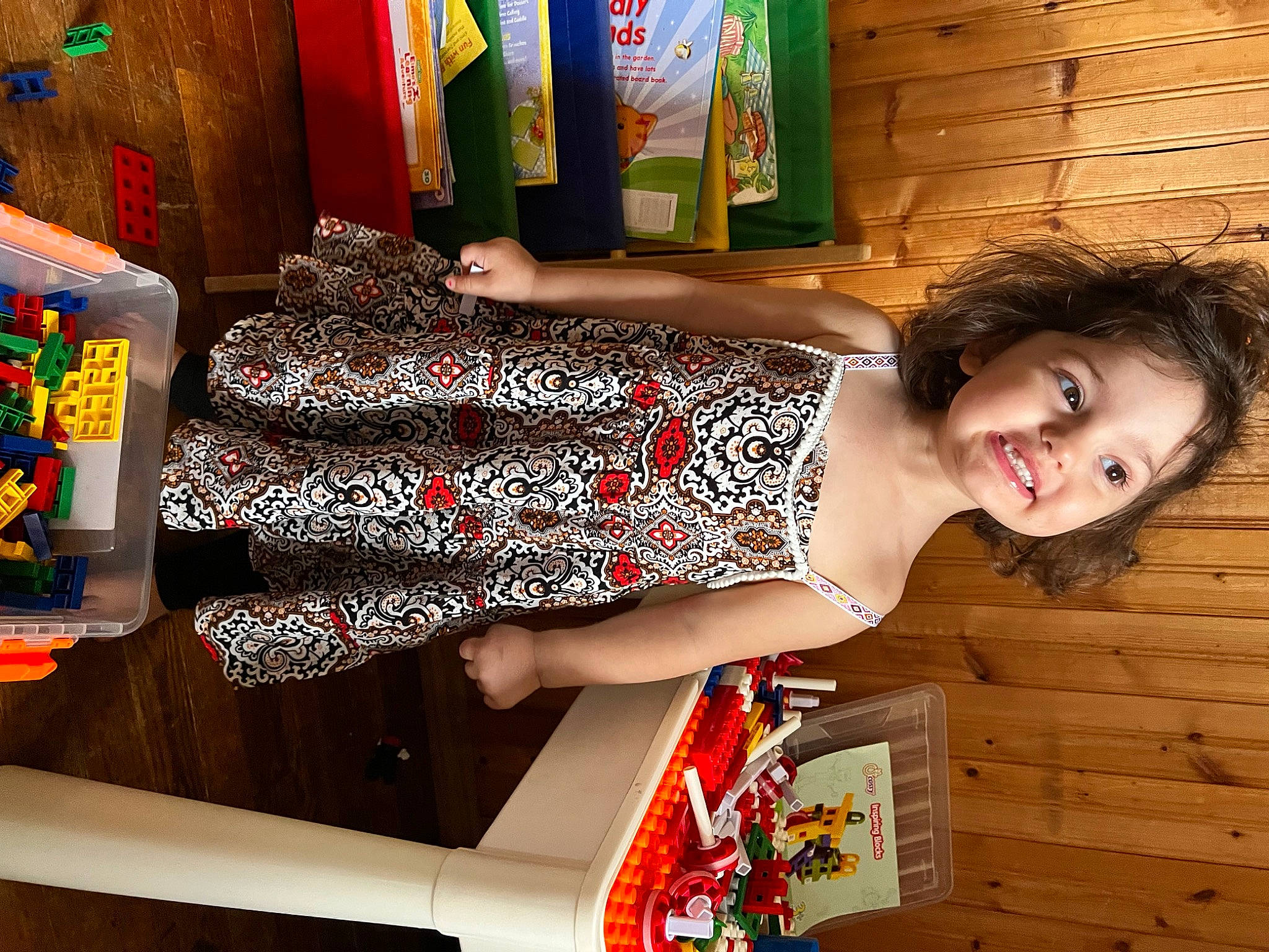 Caylee is registered to the contest to win money with this photo: child, dress, elbow, fashion_design, fun, happy, human_leg, joy, pattern, person, room, shelf, shelving, shoulder, sitting, smile, textile, thigh, trunk, waist