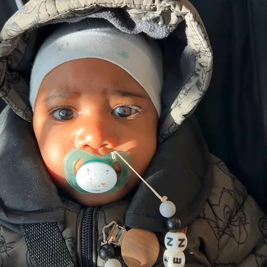 Owen participe au concours pour gagner de l'argent avec cette photo : baby, child, pacifier, hooded_jacket, car_seat, straps, face, headwear, infant, winter_clothing, cute, expression, safety, indoor, soft_light, closeup, portrait, newborn, warm, bundle