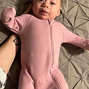 Nova joined the competition — help win amazing prizes! baby, infant, pink_onesie, blanket, hand, tattoo, face, person, lying_down, clothing, texture, bed, cute, newborn, portrait, child, sleepwear, soft, indoor, expression